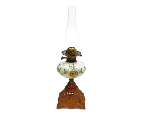 A late 19th Duplex oil lamp, with an opaque floral decorated central reservoir, on a pierced floral decorated cast iron base,