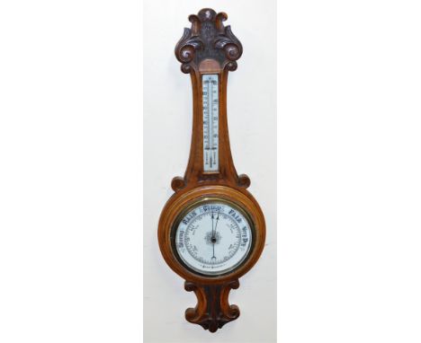 A Victorian oak cased aneroid barometer, with mercury Fahrenheit and centigrade measures, the case with carved scroll and lea