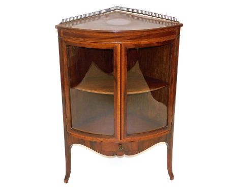 An Edwardian mahogany bow front corner cabinet, with satinwood cross banding and ebony line inlay, with a brass galleried top