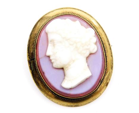 A late 19thC chalcedony and mounted cameo brooch, bust portrait of a lady, in an oval yellow metal frame, with safety chain a