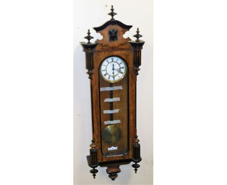 A late 19thC walnut and ebony cased Vienna wall clock, the circular enamel dial bearing Roman numerals with brass chapter rin