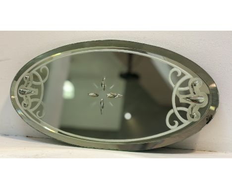 An oval  frameless mirror, with beveled glass panel with etched start centre and foliate design to edge with clear glass on t