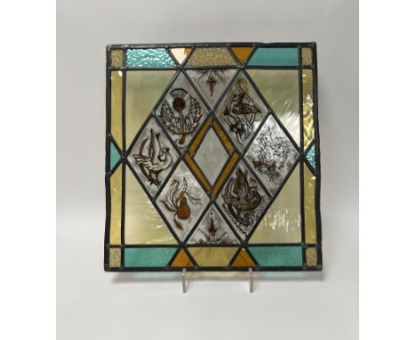 A Ramsay Gillies stained glass window panel, decorated with a thistle, a pear, a dove etc in diamond form panels (h. 45cm x w