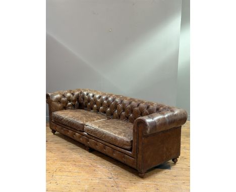 An American Restoration Hardware brown hide distressed finish three seater Chesterfield sofa with button back, on turned wood