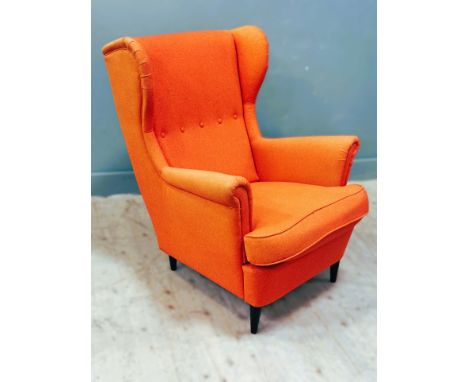 Glenmorangie: a modern wing back 1950s inspired easy chair in Glenmorangie orange, with button back and squab cushion, on ebo