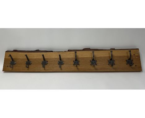 A wooden wall mounting hat and coat rack complete with eight hooks, GNER to the back of four hooks, four with embossed Britis