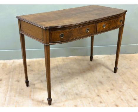 An early 20thc mahogany bow fronted hall table, fitted two frieze drawers, on square tapered supports and spade feet (h.77cm 