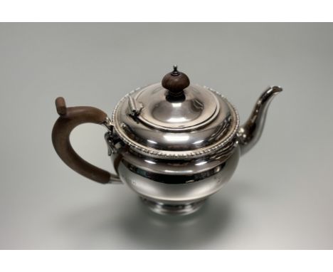 An Edwardian London silver morning teapot with turned wood knop and handle and gadroon bordered top on stepped base London 19