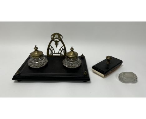 A Victorian footed rectangular inkwell with a carved black slate casing, with faceted glass inkwells finished with brass tops