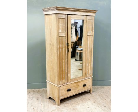 A late 19thc bleached oak wardrobe, with moulded cornice and inset mirror panel door, the interior fitted hanging rail and co