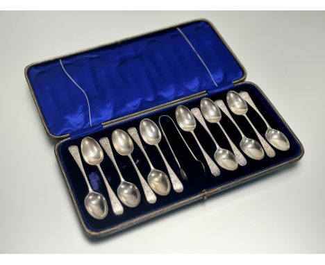 A set of twelve Sheffield silver old english pattern engraved teaspoons complete with matching tongs with engraved initials M