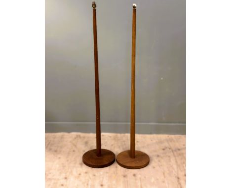 A pair of 1970s teak tapered floor standing lamps on circular bases- note one is slightly lighter in colour: h. x 149cm d. x 