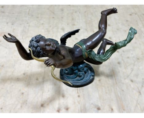 A modern cast brass garden feature of a winged cherub with bronzed finish and green enamelled sash on scrolling circular base