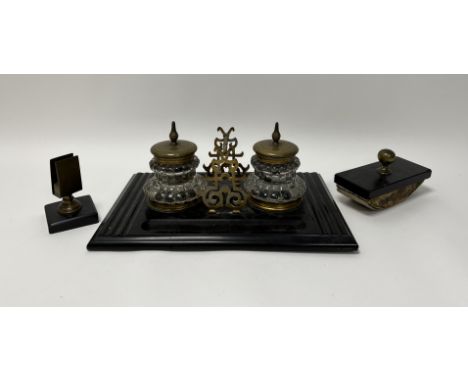 A Victorian footed rectangular inkwell on a carved black slate casing, with faceted glass inkwells finished with brass tops a