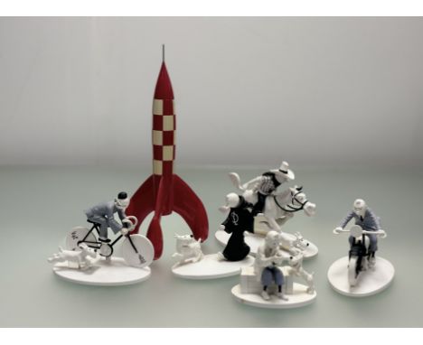 A collection of Tintin resin figures comprising, Tintin on a motorbike, seated Tintin and Snowy looking at an object, Tintin 