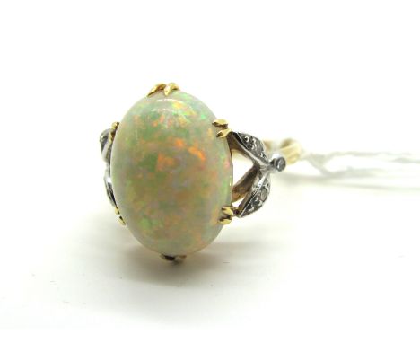 A Large Single Stone Opal Ring, the high oval cabochon six split claw set, between bifurcated diamond set shoulders, indistin