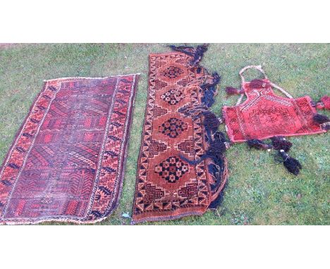 An Oriental design rug, in red and brown, 54ins x 38ins, together with two other decorative carpet wall hangings