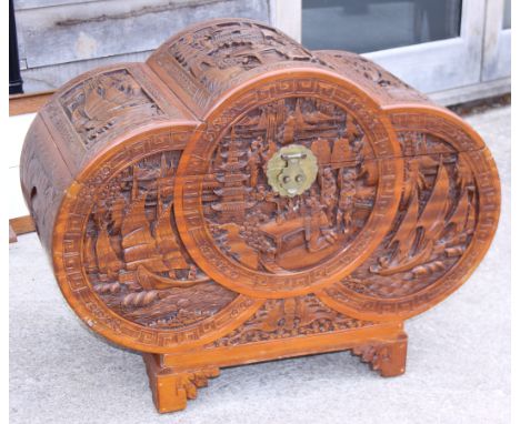 An early 20th century Chinese carved camphor wood chest with domed hinged lid, on stylised bracket supports, 38" wide 