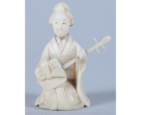 An early 20th century Ivory netsuke of a seated female playing a stringed instrument, 2 1/4" high 