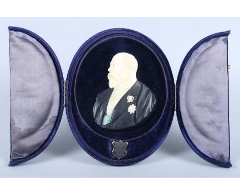 An early 20th century ebony and ivory relief portrait of Edward VII, signed W P Hogh, in a velvet presentation case, bearing 