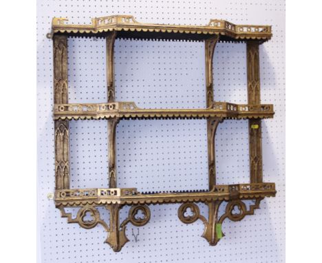 A 19th century Gothic gilt framed three-tier open fret work wall shelf, 28" wide 