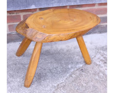 A rustic oak tree trunk stool, on three splay supports, and a teak occasional table, on tripod supports 