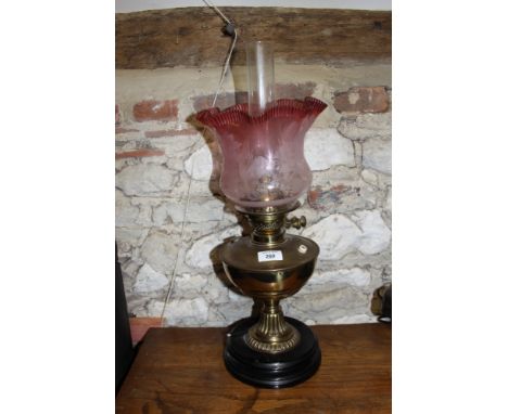 A Victorian brass oil lamp (now converted to electricity) with etched cranberry and clear glass shade, 23" high 