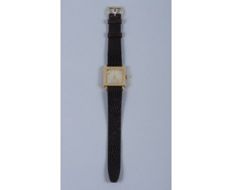 A Jaeger LeCoultre wristwatch in 18ct gold square textured case, with golden dial, baton numerals and manual movement, on bro