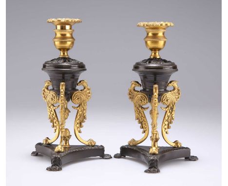 A PAIR OF REGENCY PATINATED AND GILT BRONZE DWARF CANDLESTICKS, IN THE MANNER OF CHENEY, LONDON  the urn-shaped sconces raise