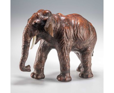A 20TH CENTURY LIBERTY STYLE LEATHER CLAD MODEL OF AN INDIAN ELEPHANT with black glass inset eyes and plastic tusks. 23cm hig