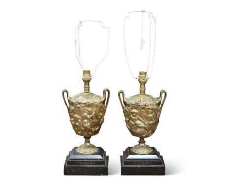 A PAIR OF 19TH CENTURY BRONZE TABLE LAMPS each two-handled urn cast with frolicking putti, raised on stepped polished slate b