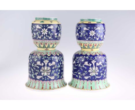 A PAIR OF CHINESE BLUE-GROUND VASES of unusual bell-shape, enamel decorated with scrolling foliage. (2) 22.5cm high