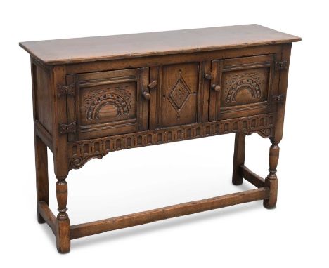 A CHAPMAN'S SIESTA OAK DRESSER BASE with a pair of panel doors, raised on baluster legs joined by stretchers, unsigned. 75.5c