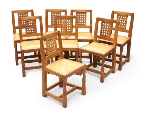 ROBERT THOMPSON OF KILBURN, A SET OF EIGHT MOUSEMAN OAK DINING CHAIRS each with openwork carved lattice back panel, leather s