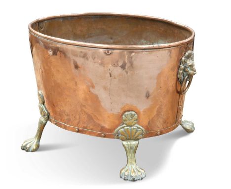 AN EARLY 20TH CENTURY BRASS-MOUNTED COPPER WINE COOLER oval, with brass lion-mask ring handles and paw feet. 44cm wide overal