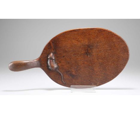 ROBERT THOMPSON OF KILBURN, AN EARLY MOUSEMAN OAK CHEESEBOARD oval form, adzed exterior, with carved mouse signature. 35cm by