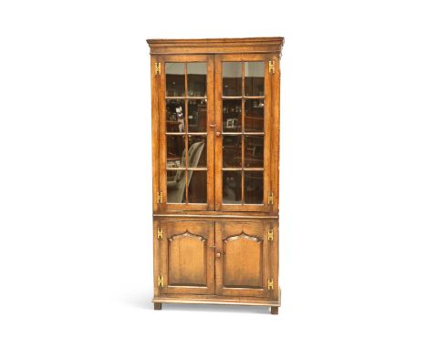 A CHAPMAN'S SIESTA OAK BOOKCASE with a pair of glazed doors, enclosing three adjustable shelves, over a pair of pointed-panel