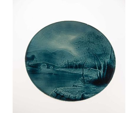 HAROLD LEACH FOR BURMANTOFTS, A FAÏENCE POTTERY CIRCULAR WALL PLAQUE  decorated with a landscape with a lake and bridge in th