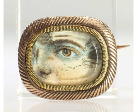AN EARLY 19TH CENTURY EYE MINIATURE depicting the cropped portrait of a young lady with light brown eyes and tight brown curl