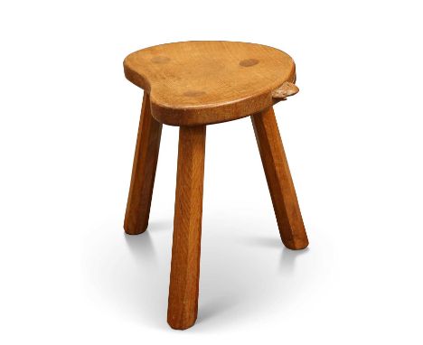 ROBERT THOMPSON OF KILBURN, A MOUSEMAN OAK MILKING STOOL with kidney-shaped seat, lightly adzed, raised on three faceted legs