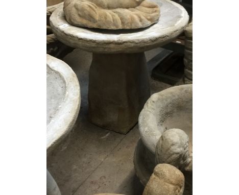 A large bird bath on boulder pedestal 