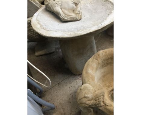 A large bird bath on boulder pedestal 