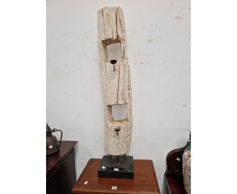 A CREAM PAINTED DRIFTWOOD TREE TRUNK PIERCED WITH TWO SQUARE HOLES AND PIERCED WITH TWO BLACK METAL CANDLE HOLDERS.   H 117cm