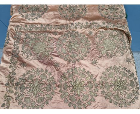 AN ISLAMIC PINK SILK PANEL SEWN IN GOLD THREAD WITH STAR CENTRED ROUNDELS WITHIN BUD SPANDRELS AND VINE BANDS.   96 x 100cms.