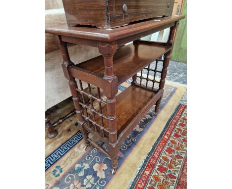 AN ARTS AND CRAFTS OAK OPEN BOOKCASE, THE LOWER SHELF ENCLOSED BY A SQUARE NET OF BARS JOINING THE TURNED LEGS ON THE NARROW 