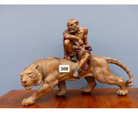 A CHINESE RED WARE FIGURE OF AN IMMORTAL (POSSIBLY ZHONGLI QUAN) RIDING A TIGER, SEAL MARK. W 36cms.