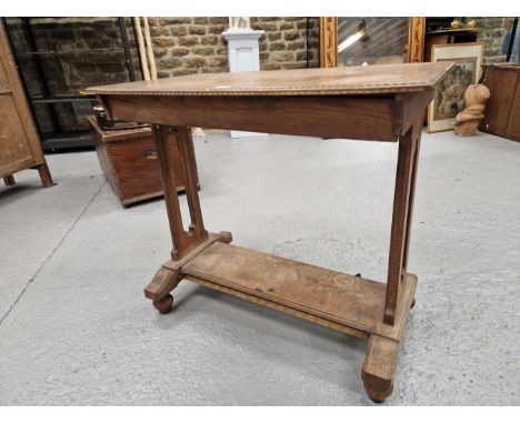 A HEALS TYPE OAK SIDE TABLE, THE TOP WITH A CHIP CARVED EDGE ABOVE TWIN PILASTERS TO EACH NARROW END JOINED BY A SHELF TIER A