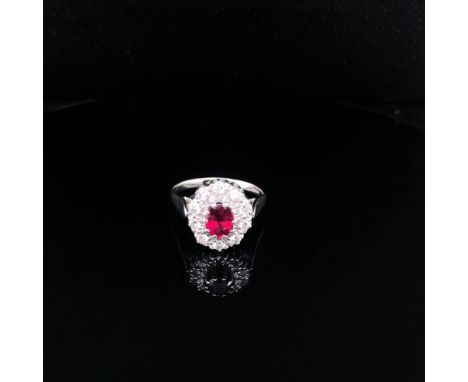 AN 18ct WHITE GOLD HALLMARKED AND HIGH QUALITY RUBY AND DIAMOND CLUSTER RING. THE OVAL CLAW SET RUBY IN A 10 CLAW SETTING. TH