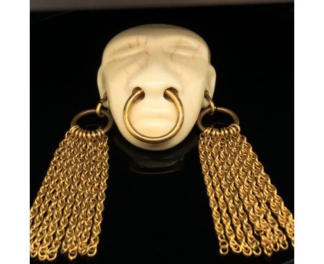 A JOSEFF OF HOLLYWOOD VINTAGE HEAD HUNTER BROOCH, THE HEAD WITH CHAINED TASSEL EARRINGS AND AN OVERSIZED NOSE RING. THIS BOOK
