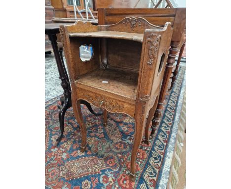 A 19th C. FRENCH OAK BEDSIDE CUPBOARD, THE THREE QUARTER GALLERIED TOP ABOVE AND OPEN SHELF, THE DRAWER BELOW CARVED WITH BLO